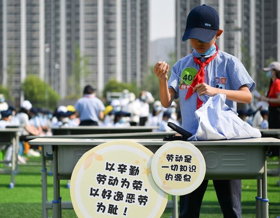2022年5月7日，西安市后宰门小学的学生参加缝扣子比赛。新华社记者 张博文 摄